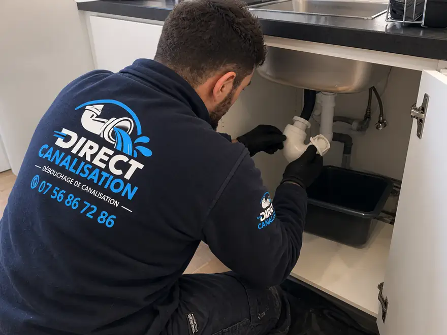 Technicien Direct Canalisation démontant le siphon d'un évier de cuisine à Lyon